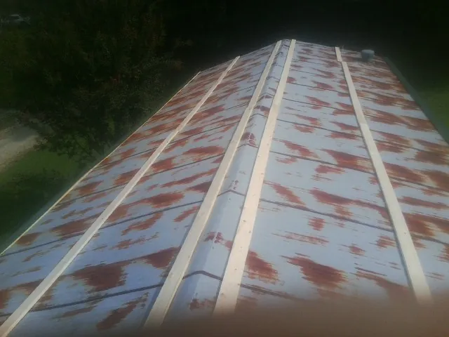 Rusted metal roof panels with new wood purlins before replacement — Storm Damage Roof Repair in Sharpsburg by Roofing Brothers